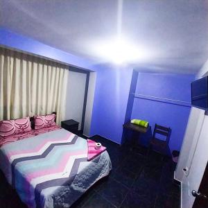 a blue bedroom with a bed and a chair at PAKKARIN - HOTEL in Chachapoyas