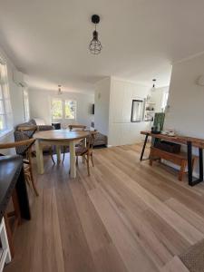 a living room with a table and a couch at Ohariu Farm Cottage in Johnsonville