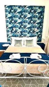 a bedroom with a large bed with a blue wallpaper at Marcel Zadar Old Town in Zadar