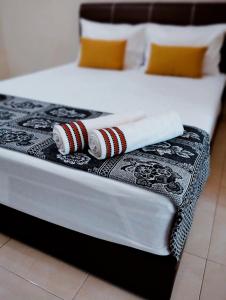 a bed with two towels and two pillows on it at Muslim 2 Stay in Malacca