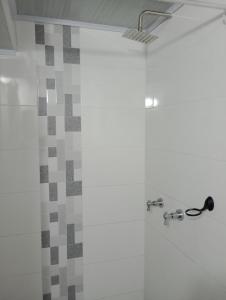 La salle de bains est pourvue d'une douche et d'une porte en verre. dans l'établissement Aparta estudio Fontanar del río suba, à Bogotá