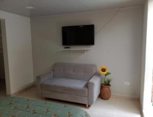 - un salon avec un canapé et une télévision murale dans l'établissement Aparta estudio Fontanar del río suba, à Bogotá
