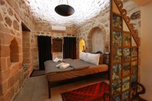 Şems Inn في ماردين: غرفة نوم بسرير في جدار حجري