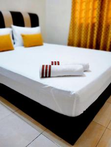 Una cama con dos toallas blancas encima. en Muslim 2 Stay en Melaka