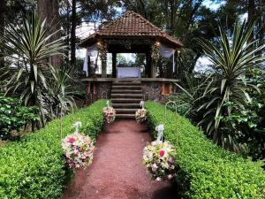 einen Gang, der zu einem Pavillon mit Blumen führt in der Unterkunft Hacienda Venta de Guadalupe in La Venta