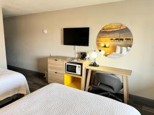 a hotel room with a desk with a tv and a bed at Days Inn by Wyndham Van Horn TX in Van Horn