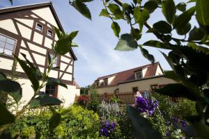 una casa con jardín y flores en Pension Alte Schmiede, en Zabeltitz