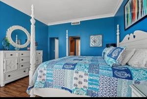 Un dormitorio azul con una cama blanca y una cómoda blanca en Penthouse North Myrtle Beach, en Myrtle Beach