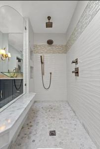 baño blanco con ducha y lavamanos en Penthouse North Myrtle Beach, en Myrtle Beach