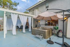 een patio met een parasol en een grill bij Family Fun House with Heated Pool & Hot Tub & Pool Table in Chandler in Chandler