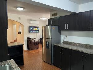 a kitchen with a stainless steel refrigerator and black cabinets at Casa grande y centrica, 3 cuartos y 2 baños in Hermosillo +13 photos