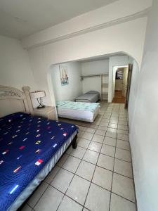 um quarto com 2 camas e piso em azulejo em Casa grande y centrica, 3 cuartos y 2 baños em Hermosillo