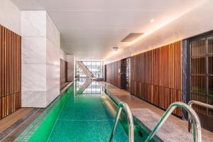 una piscina cubierta en un edificio con azulejos verdes en KULA Melbourne CBD, en Melbourne