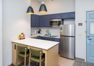 uma cozinha com armários azuis e um frigorífico de aço inoxidável em Staybridge Suites Jackson, an IHG Hotel em Ridgeland