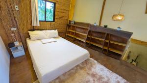 a bedroom with a bed with a laptop on it at Tropical Haven with Dedicated Office Space in Siargao in General Luna
