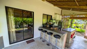 a kitchen with a counter and stools in a room at Tropical Haven with Dedicated Office Space in Siargao in General Luna