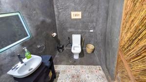 a bathroom with a white toilet and a sink at Tropical Haven with Dedicated Office Space in Siargao in General Luna +4 photos