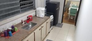 a kitchen with a sink and a counter top at Suíte luxo com sacada mobiliada Q1 in Campinas