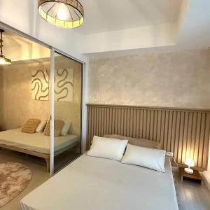 - une chambre avec un grand lit blanc et un miroir dans l'établissement Great for Staycation for Family in Azure Beach, à Tanza