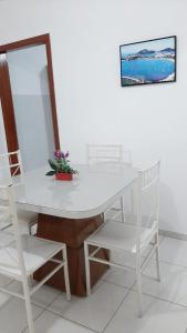 une table blanche avec deux chaises blanches et un miroir dans l'établissement Jockey Family_Suave, à Vila Velha