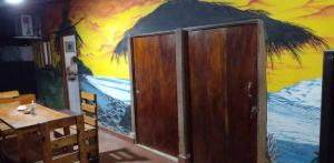 uma sala de jantar com um quadro na parede em La Casita em El Zonte