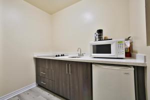 a kitchen with a microwave on top of a counter at King Hotel in Palmerston