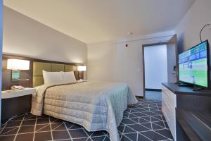 a hotel room with a bed and a flat screen tv at King Hotel in Palmerston