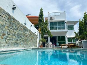 a swimming pool in front of a house at White House near Thunderbird Resort in Parian