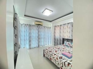 1 dormitorio con 1 cama con cortinas azules y rosas en White House near Thunderbird Resort, en Parian