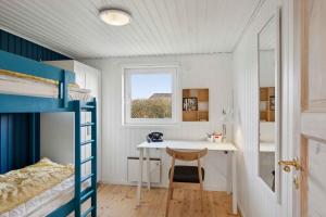 a bedroom with a desk and a bunk bed at Summer House With Sauna Near Flle Strand, in Rønde