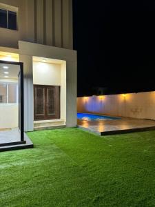 a house with a green lawn at night at Dreams Resorts in Sinādil