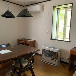 ein Esszimmer mit einem Tisch und einer Mikrowelle in der Unterkunft Kitakaruizawa Morino Bessou NO5 in Tsumagoi