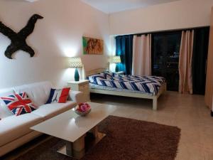 a living room with a couch and a bed at [The One Studios] - JLT - Lakes view Apartments in Dubai