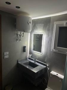 W łazience znajduje się umywalka, lustro i toaleta. w obiekcie Alhosry rose motel w mieście 6th Of October (Miasto 6 października)