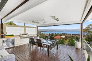 een keuken en eetkamer met een tafel en stoelen bij HEATed Pool, Lake & Beach, Luxury 5 B/R House in Lake Illawarra