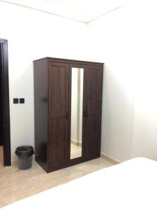 um armário de madeira com um espelho num quarto em Distinctive chalet in Dur.Marina em Durat Alarous
