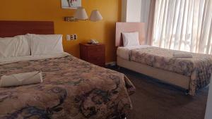 Habitación de hotel con 2 camas y ventana en CORONA, en Puno