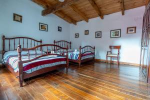 1 Schlafzimmer mit 2 Betten und Holzboden in der Unterkunft Hacienda Venta de Guadalupe in La Venta + 29 Fotos
