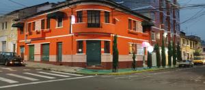 an orange building on the side of a street at HOSTAL CALIFORNIA in Quito +19 photos