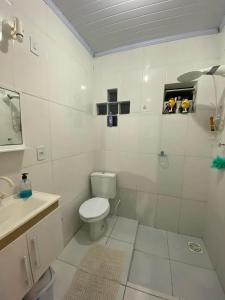 uma casa de banho branca com um WC e um lavatório em Pousada bananeiras em Criciúma
