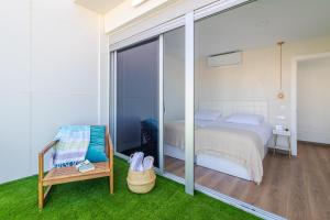 Schlafzimmer mit einem Bett und einer Glasschiebetür in der Unterkunft Flatguest Luxury Beach Terrace Loft - WIFI in Las Palmas de Gran Canaria