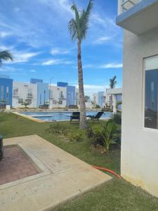 un palmier à côté d'un bâtiment avec une piscine dans l'établissement Casa Regina, à Gallinero