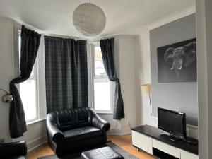 a living room with a leather chair and a television at shardeloes in London