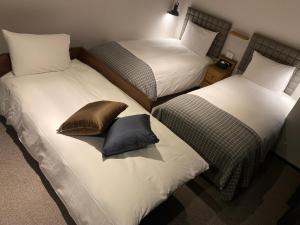 Duas camas individuais com almofadas num quarto em Hotel Resol Stay Akihabara em Tóquio