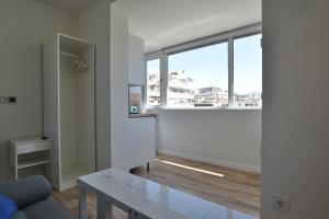 a living room with a table and a large window at Ático Panorama Catedral in Granada