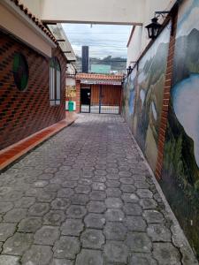 eine leere Gasse mit Gemälden an der Seite eines Gebäudes in der Unterkunft Hostal Rincón Del Turista in Otavalo