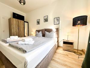 a bedroom with a large bed with two towels on it at FEWO Gleis 1 in Oberstaufen +8 photos