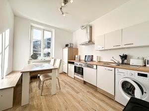 a kitchen with a table and a laundry machine at FEWO Gleis 1 in Oberstaufen