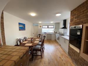 uma cozinha e sala de jantar com mesa e cadeiras em 4-Bedroom home - Perfect for those working in Bridgend - By Tailored Accommodation em Bridgend