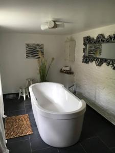 een wit bad in een badkamer met zwarte tegels bij Katharinenhof Ferienwohnung Küste in Tönning